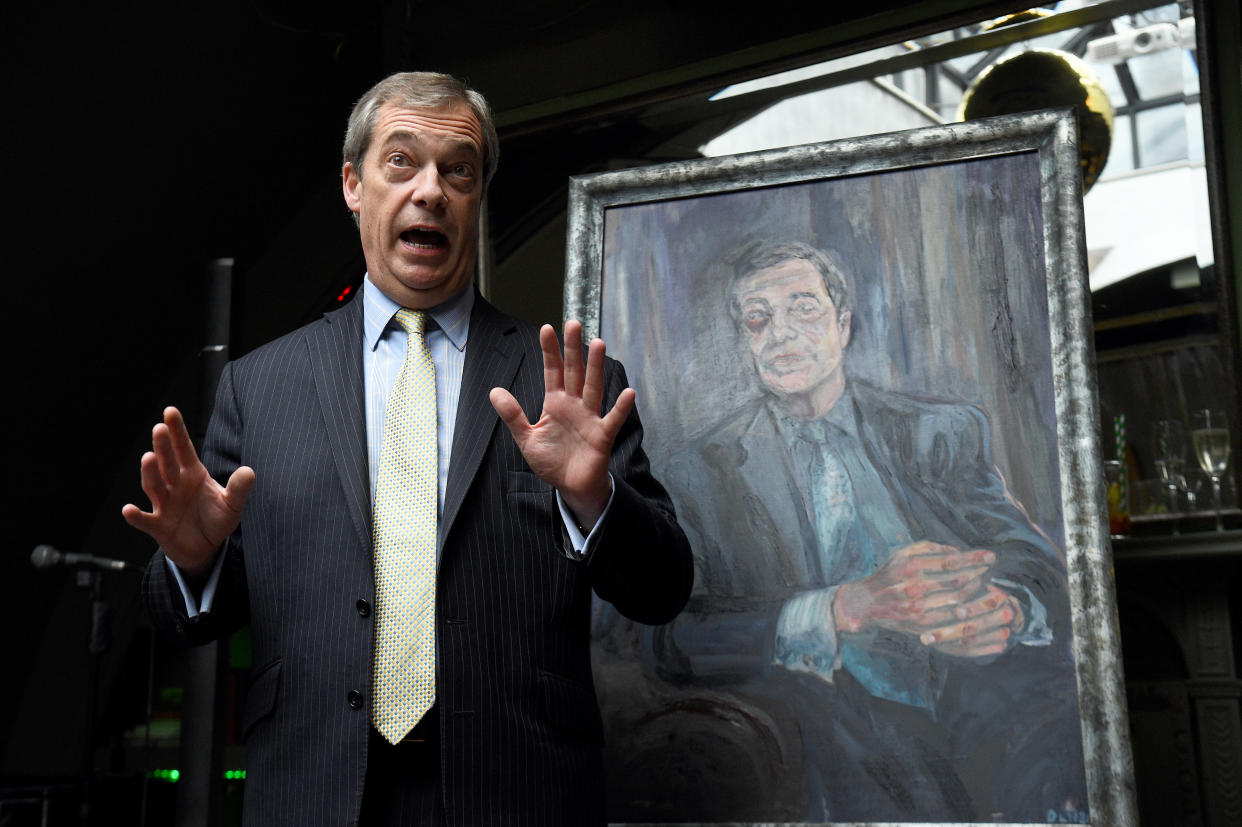 Nigel Farage stands beside a portrait of himself titled Mr Brexit, by artist Dan Llywelyn Hall, at L'Escargot Restaurant in London.