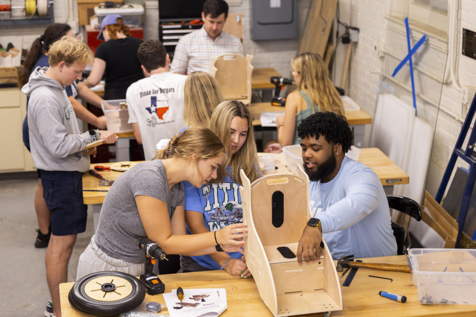 This photo released by Tulane University shows Tulane biomedical engineering students building specially designed mobility chairs for children at the MakerSpace workshop at the university Sunday, Sept. 24, 2023. The students are making the second batch of mobility chairs for toddlers, that will eventually go to pediatric patients at Children's Hospital. Wheelchairs are expensive, and insurance won't cover the cost for children unless the child proves they can operate it independently. (Sabree Hill/Tulane University via AP)