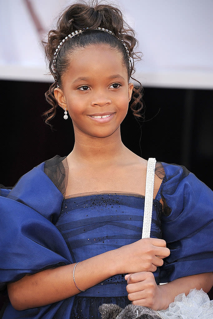 Quvenzhané. in an elegant off-the-shoulder dark dress with a headband, posing on the red carpet