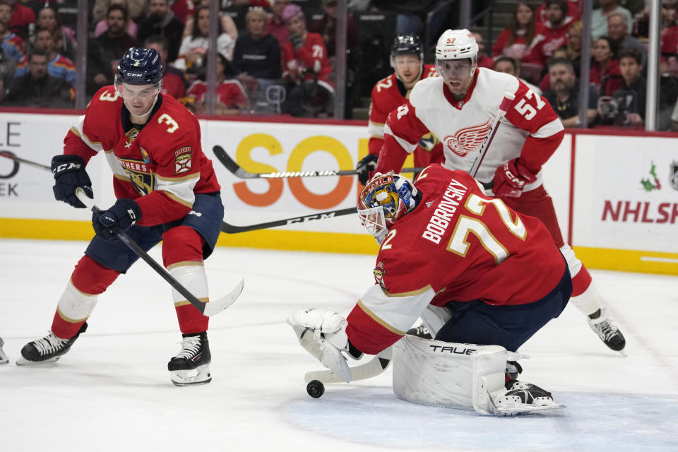 Florida Panthers goaltender Sergei Bobrovsky (72) makes a save as Florida Panthers defenseman Matt Kiersted (3) and Detroit Red Wings left wing David Perron (57) watch during the first period of an NHL hockey game Thursday, Dec. 8, 2022, in Sunrise, Fla. (AP Photo/Lynne Sladky)