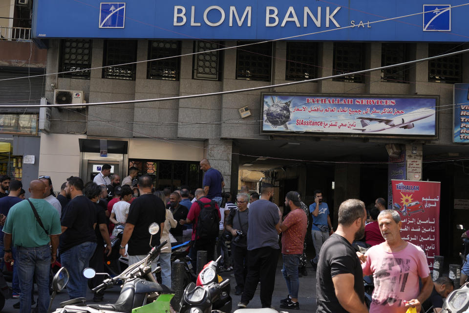 Media and security gather outside BLOM bank branch where a man who is identified as Abed Soubra is allegedly holding hostages in an effort to get to funds in his account in Beirut, Lebanon, Friday, Sept. 16, 2022. Depositors broke into at least four banks in different parts of crisis-hit Lebanon Friday demanding that they get their trapped savings as chaos spreads in the small Mediterranean nation in the middle of a historic economic meltdown. (AP Photo/Bilal Hussein)