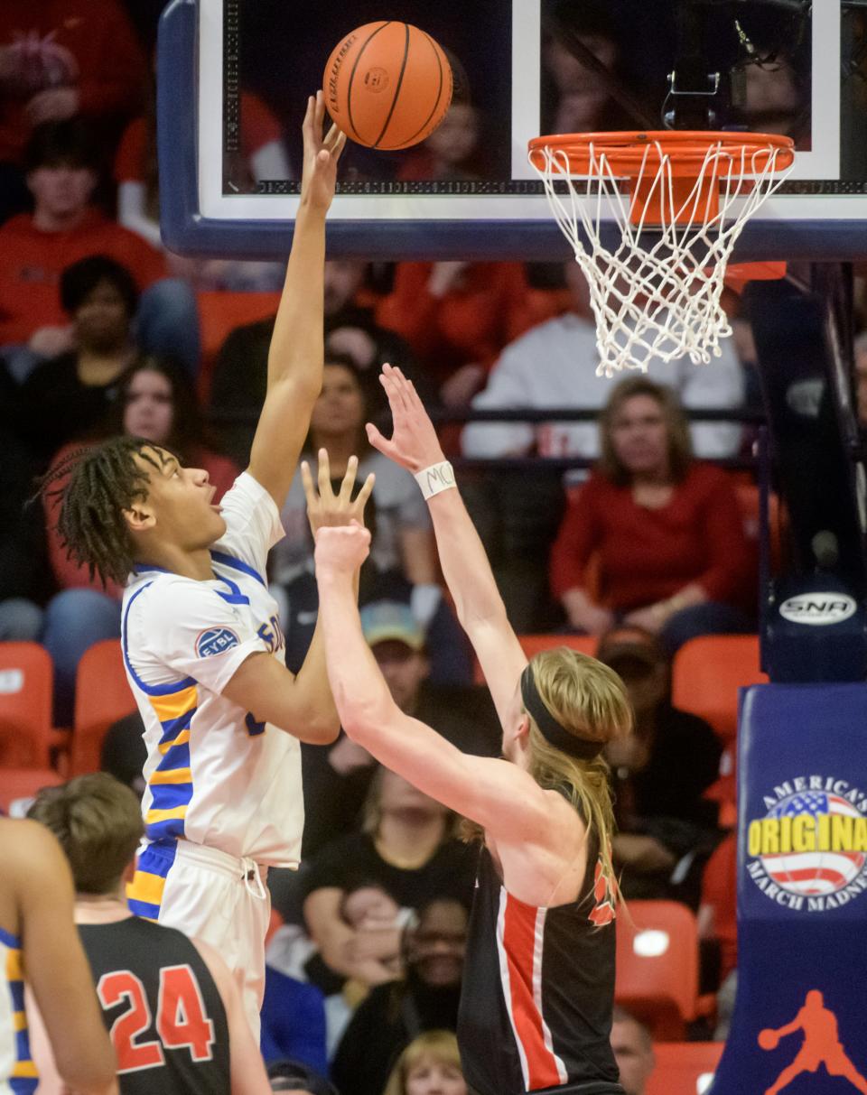 Chicago Simeon's Miles Rubin, left, puts up a shot over Metamora's Ethan Kizer in the first half of the Class 3A basketball state title game Saturday, March 11, 2023 at State Farm Center in Champaign. The Redbirds took the title 46-42.