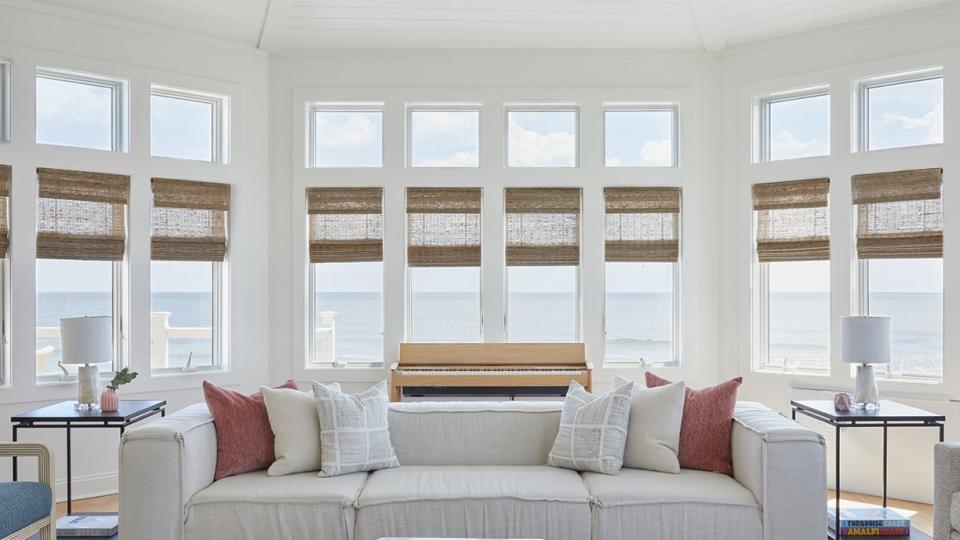 a living room with a white couch and throw pillows