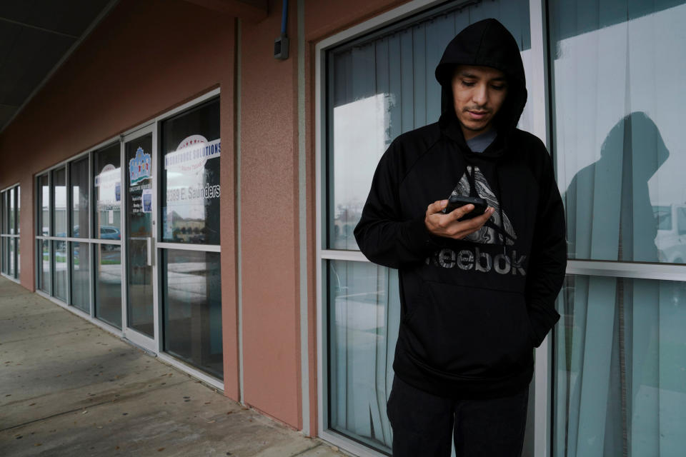 Alberto Mendoza checks a website to apply for unemployment benefits outside of the Workforce Solutions for South Texas offices in Laredo, Texas, U.S., March 20, 2020. Picture taken March 20, 2020. REUTERS/Veronica G. Cardenas