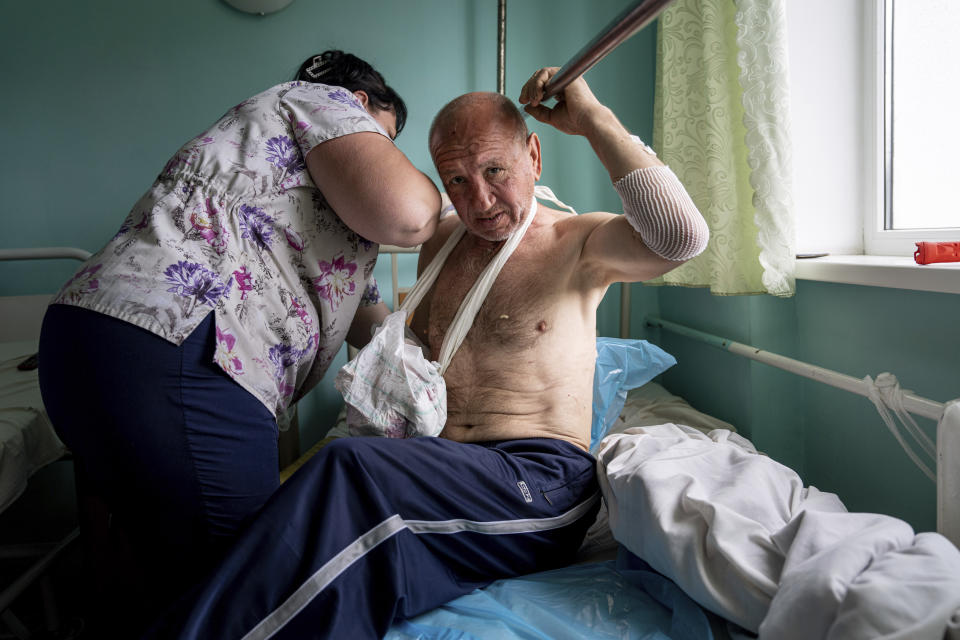 Vitalii Shpalin, de 60 años, sentado en la cama de un hospital de la región de Jersón, Ucrania, el 12 de junio de 2023, tras recibir un disparo mientras huía en barco de la anegada localidad de Kardashynka, en la orilla izquierda del río Dniéper, en una zona controlada por Rusia. Contó que su embarcación fue baleada por soldados rusos posicionados en una casa cercana. Shpalin los vio. “(Los rusos) dejaron pasar a los botes que venían a rescatar a gente”, dijo. “Pero cuando estaban llenos de gente, comenzaban a disparar”. (AP Foto/Evgeniy Maloletka)