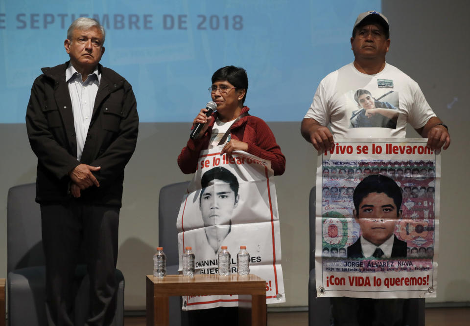 ADDS NAMES OF RELATIVES - President-elect Andres Manuel Lopez Obrador, left, stands next to Maria Elena Guerrero, center, Epifanio Alvarez, parents of some of the 43 teachers college students who disappeared on Sept. 26, 2014, at the Memory and Tolerance Museum in Mexico City, Wednesday, Sept. 26, 2018. Later in the day, family members and supporters, who do not accept the findings of government investigations, will march to mark four years since the students disappearance at the hands of police. (AP Photo/Rebecca Blackwell)