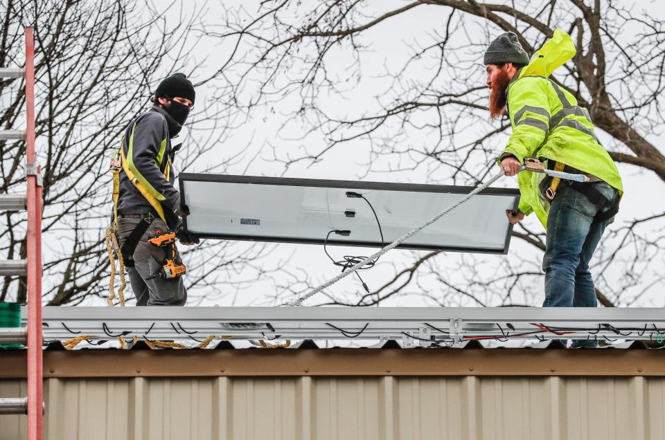 Representatives from GRNE Solar, Branch Manager Kendall Ludwig, left, and Installer Mike Dunn, right, install solar panels at a rural property in Lebanon Ind., Monday, Dec. 21, 2020. Solar installation and other green jobs are expected to rise nearly 30% in Indiana over the next five years, according to research conducted by nonprofit WorkingNation.