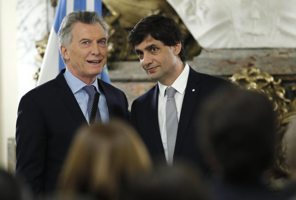 Argentina's President Mauricio Macri, left, talks to new Argentina's Treasury Minister Hernan Lacunza at the government house in Buenos Aires, Argentina, Tuesday, Aug. 20, 2019. Lacunza replaced Nicolas Dujove after the minister resigned. (AP Photo/Natacha Pisarenko)