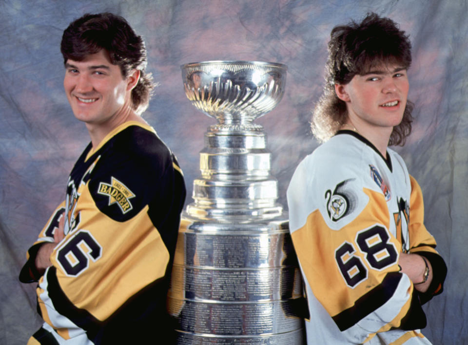 Kanadyjski profesjonalny hokeista Mario Lemieux #66 (po lewej) i czeski kolega Jaromir Jagr #68 z Pittsburgh Penguins stoją z Pucharem Stanleya, początek lat 90. Pens zdobyli trofeum mistrzowskie w 1991 i 1992 roku. (Zdjęcie Bruce Bennett Studios via Getty Images Studios/Getty Images) 