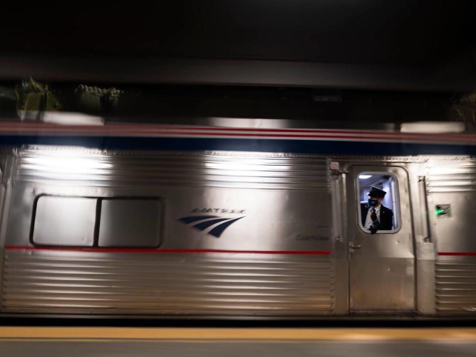 An Amtrak employee looks out the window as the train pulls out of a station in this 2021 file photo. Amtrak service between Vancouver and Seattle is set to be on the tracks two months earlier than expected. (Eakin Howard/Lincoln Journal via AP Photo - image credit)