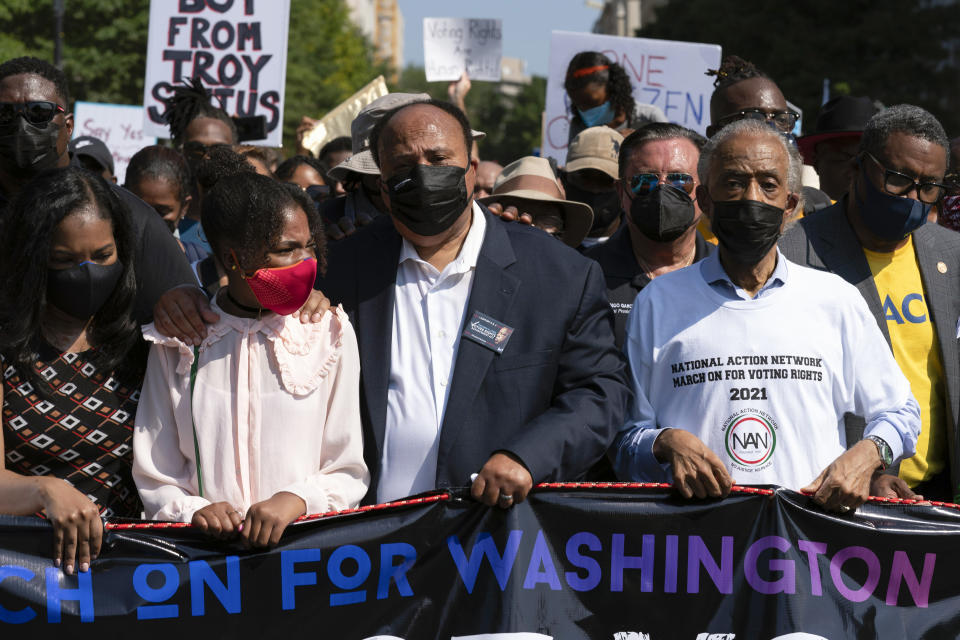 The Rev. Al Sharpton, right, holds a banner with Martin Luther King, III, third from right, during a march for voting rights, marking the 58th anniversary of the March on Washington, Saturday, Aug. 28, 2021, in Washington. Hundreds of thousands of voting rights advocates rallied across the country Saturday to call for sweeping protections against a further erosion of the Voting Rights Act of 1965. (AP Photo/Jose Luis Magana)