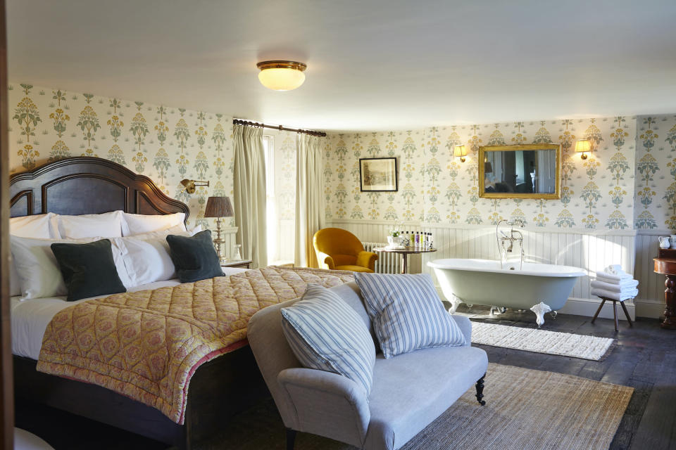 <p> If you&apos;re fortunate enough to have a large space, consider adapting your country bedroom ideas to incorporate a seating area and even a freestanding bath tub, to create a luxurious open concept suite. </p> <p> Country hotel style is the place to look for inspiration, such as this room created by interior designer&#xA0;Alexander Waterworth&#xA0;at Soho Farmhouse.&#xA0; </p> <p> You&apos;ll want a sense of separation between your sleeping space and the bathing zone, so define each area with a rug or a different decorative backdrop, such as a change in wallpaper or paint color. </p>