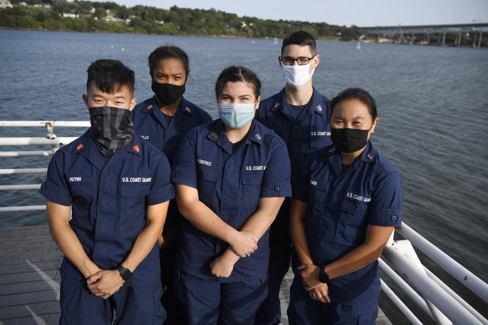 In this Monday Sept. 14, 2020 photo, From the left, Coast Guard Academy Cadets Tyler Huynh, Branyelle Carillo, Mia Haskovec, Henry Smith, and Jordan Park, pose for a photograph at the Seamanship Sailing Center at the United State Coast Guard Academy in New London, Conn. A group of Coast Guard cadets spent part of their summer filling in on a critical national security mission after a case of COVID-19 sidelined crew members on a cutter being sent to patrol the US-Russia border. (AP Photo/Jessica Hill)