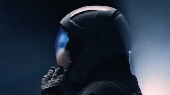  A shadowy figure in a spacesuit touches a glove to the helmet's visor. 