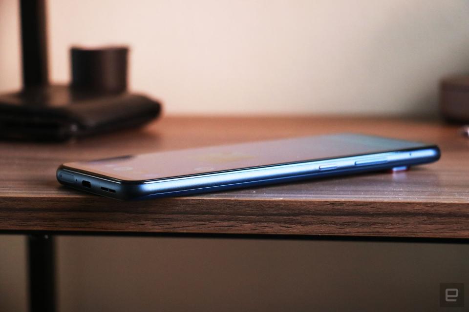 Side view of the Smartphone for Snapdragon Insiders laid on a wooden surface, showing its power and volume buttons on the right edge.