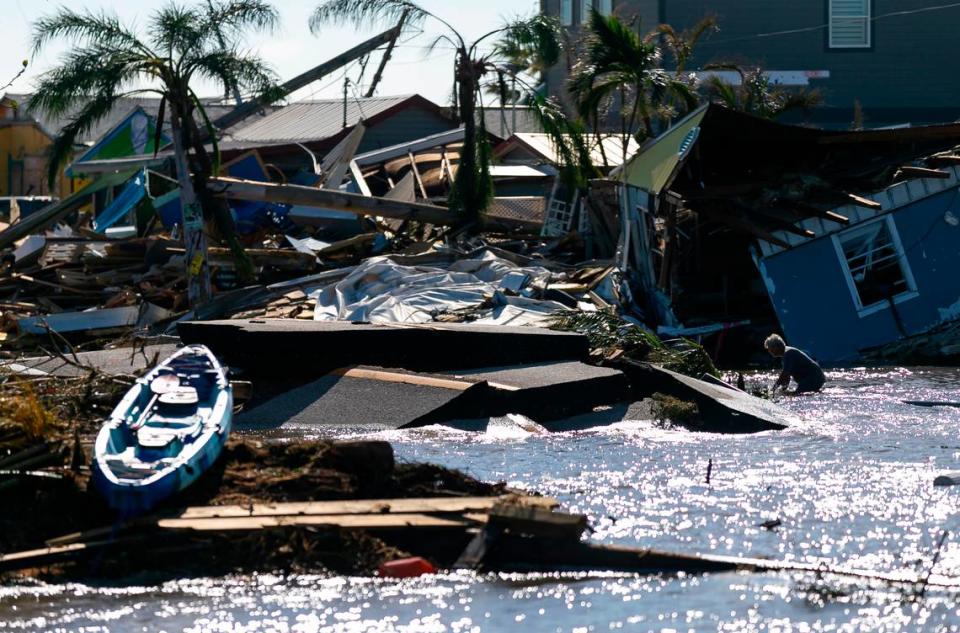 Un hombre moviéndose a través del agua del golfo que fluye a través de una sección rota de Pine Island Road el jueves 29 de septiembre de 2022, en Matlacha, la Florida. El huracán Ian tocó tierra en la costa del suroeste de la Florida como una tormenta de categoría cuatro el miércoles por la tarde, dejando zonas afectadas con calles inundadas, árboles caídos y escombros esparcidos.