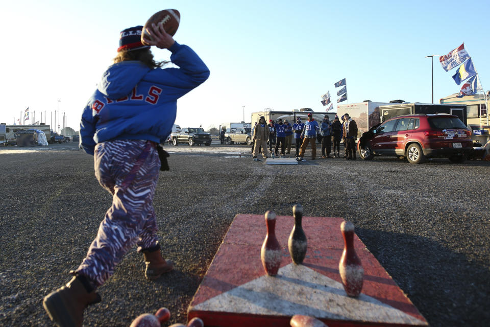 Fans tailgate as temperatures drop in the parking lots outside of Highmark Stadium before an NFL wild-card playoff football game between the Buffalo Bills and the New England Patriots, Saturday, Jan. 15, 2022, in Orchard Park, N.Y. (AP Photo/Joshua Bessex)