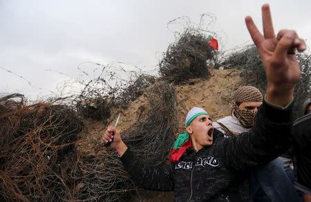 A Palestinian protester holds a knife as he shouts during clashes with Israeli troops near border between Israel and Central Gaza Strip November 6, 2015. REUTERS/Ibraheem Abu Mustafa