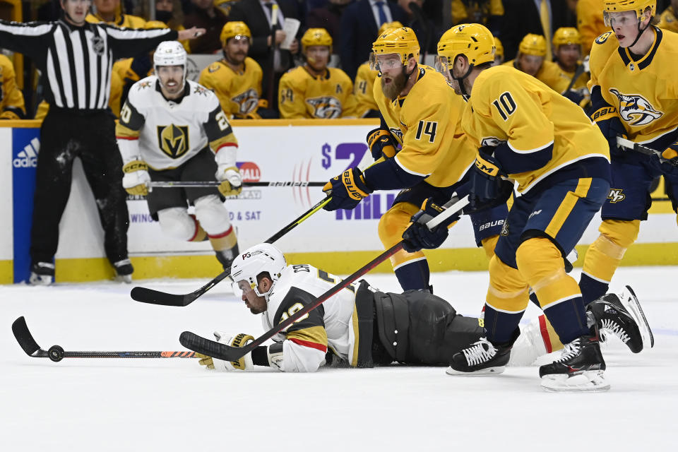 Vegas Golden Knights left wing William Carrier (28) pokes the puck away from Nashville Predators defenseman Mattias Ekholm (14) and center Colton Sissons (10) during the first period of an NHL hockey game Tuesday, Feb. 7, 2023, in Nashville, Tenn. (AP Photo/Mark Zaleski)