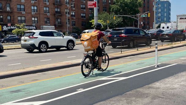 PHOTO: GrubHub delivery person on electric bike in the bicycle lane on Queens Boulevard in Queens, N.Y. (Lindsey Nicholson/UCG/Universal Images Group via Getty Images)