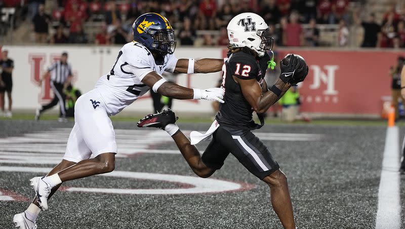 Houston wide receiver Stephon Johnson, right, beats West Virginia safety Marcis Floyd for a touchdown catch during the fourth quarter of an NCAA college football game Thursday, Oct. 12, 2023, in Houston.