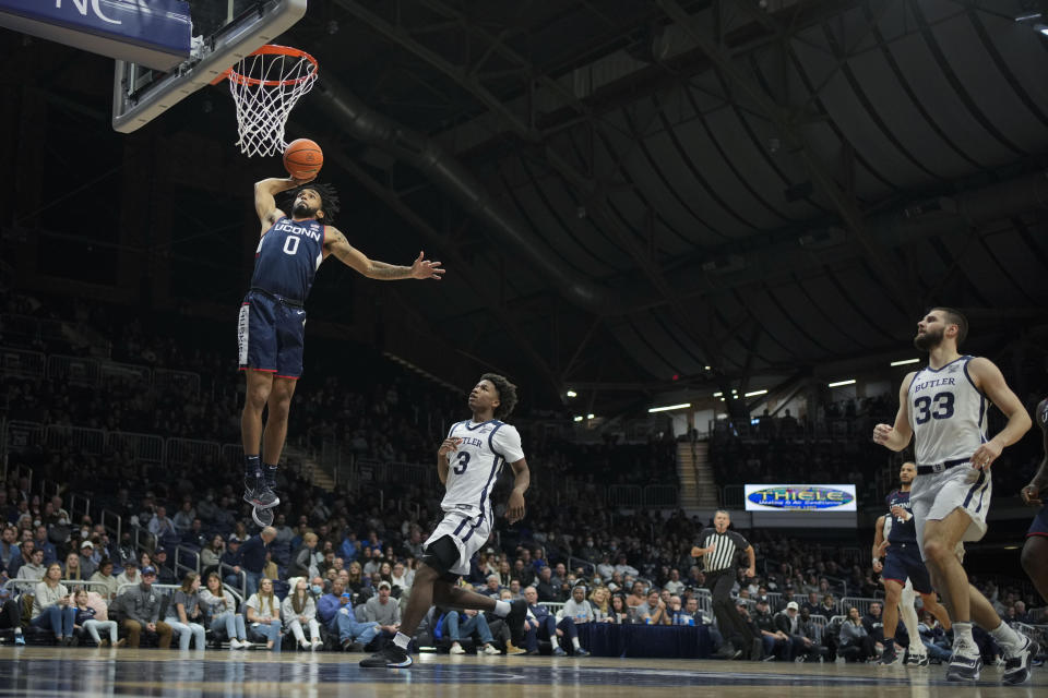 Connecticut guard Jalen Gaffney (0) dunks in front of Butler guard Chuck Harris (3) in the second half of an NCAA college basketball game in Indianapolis, Thursday, Jan. 20, 2022. (AP Photo/AJ Mast)