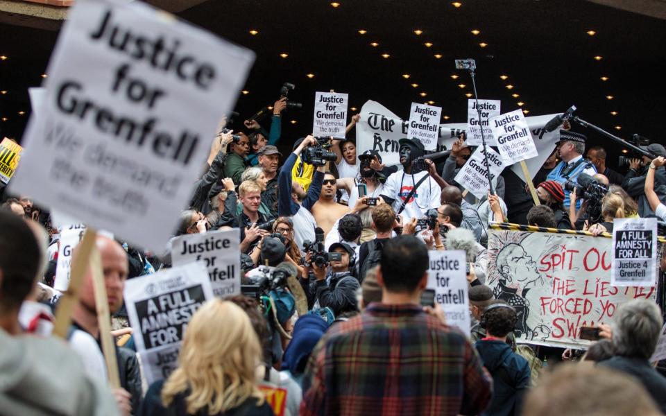 Protesters with placards and banners demonstrate outside Kensington and Chelsea Town Hall - Credit: Jack Taylor 