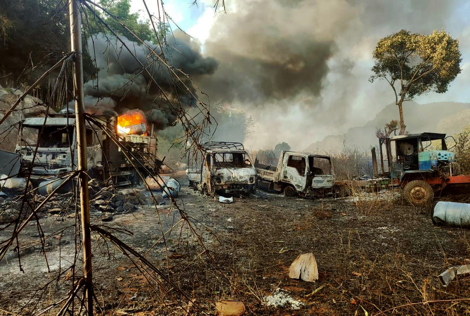 In this photo provided by the Karenni Nationalities Defense Force (KNDF), smokes and flames billow from vehicles in Hpruso township, Kayah state, Myanmar, Friday, Dec. 24, 2021. Myanmar government troops rounded up villagers, some believed to be women and children, fatally shot more than 30 and set the bodies on fire, a witness and other reports said Saturday. (KNDF via AP)