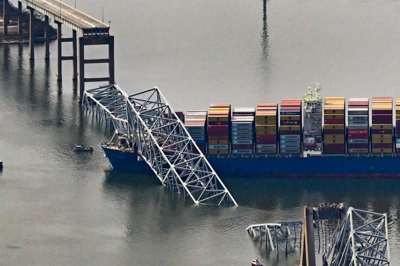 The Singapore-based damaged container ship rests next to a bridge pillar in the Patapsco River after crashing into and destroying the Francis Scott Key Bridge at the entrance to Baltimore harbor in Baltimore, Maryland on Tuesday. Several workers were atop the bridge and making repairs to the asphalt roadway when the structure collapsed. Photo by David Tulis/UPI