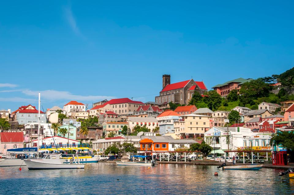 Landscape of the Carenage harbor, boats, and colorful buildings on hillside, St George's, Grenada.