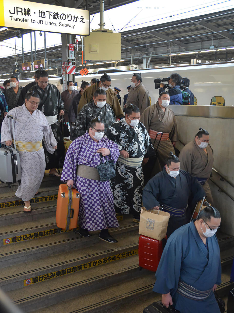 內地疫情稍見好轉，韓國及日本等鄰近地區卻紛紛爆發疫情；圖為日本相撲手前往比賽情況。