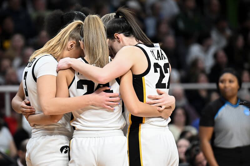 Iowa guard Caitlin Clark (22) huddles with teammates on the court before playing LSU in an Elite Eight round college basketball game during the NCAA Tournament, Monday, April 1, 2024, in Albany, N.Y. | Hans Pennink