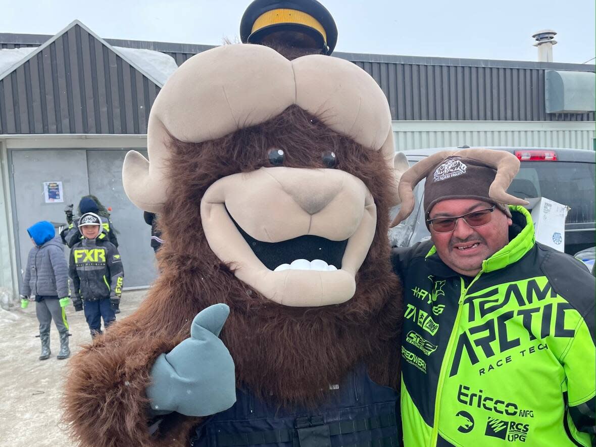 Ollie the Umingmak gives a thumbs-up with Cambridge Bay's deputy mayor Derek Elias, decked out in his muskox hat for the Umingmak Frolics parade. (Jane George/CBC - image credit)