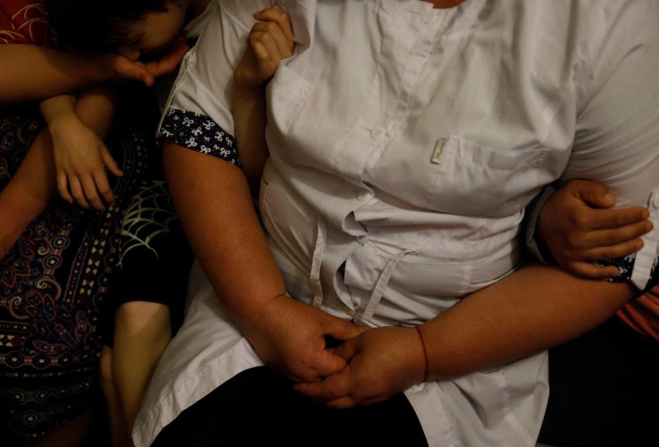 Nurse Rita Barba, 52, sits with children in the shelter (Reuters)