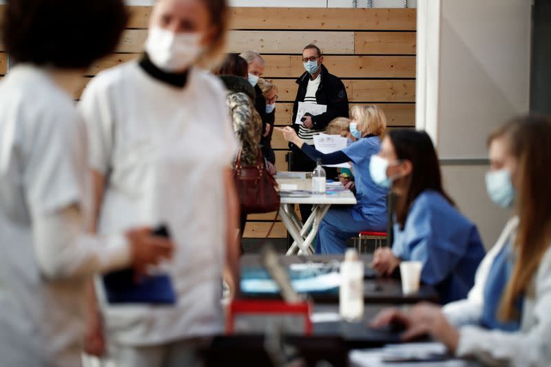 Trabajadores de la salud esperan para recibir la vacuna COVID-19 de Pfizer-BioNTech en un centro de vacunación dentro de un gimnasio en Taverny cerca de París, Francia, el 9 de enero de 2021