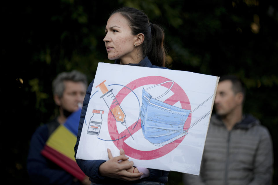 FILE - A woman holds a banner during an anti-government and anti-restrictions protest organised by the far-right Alliance for the Unity of Romanians or AUR, in Bucharest, Romania, Saturday, Oct. 2, 2021. (AP Photo/Vadim Ghirda, File)