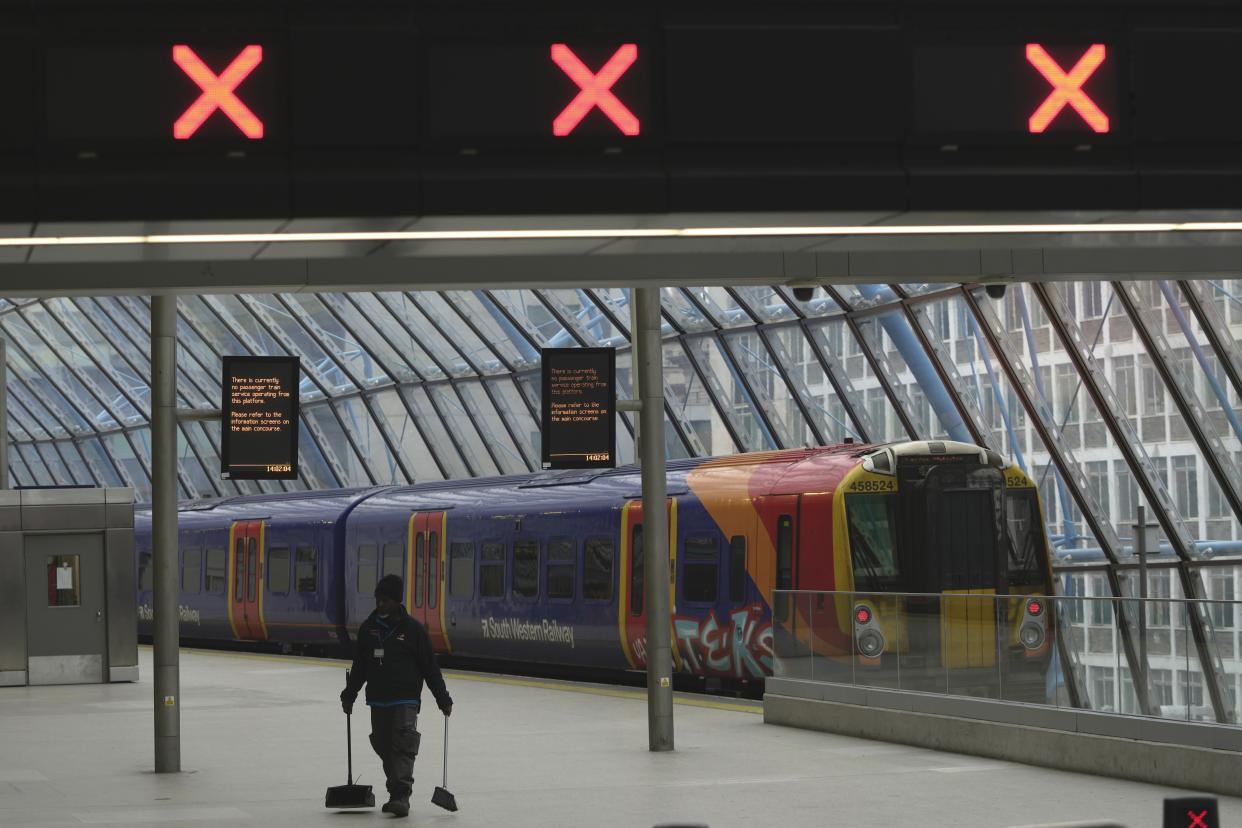 A worker cleans the floor in the Waterloo Station, in London, Wednesday, Feb. 1, 2023. Up to half a million workers are expected to go on strike across the U.K. in what's shaping up to be the biggest day of industrial action Britain has seen in more than a decade. Thousands of schools will close some or all of their classrooms, train services will be paralyzed and delays are expected at airports as teachers, university staff, civil servants, border officials and train and bus drivers walk out of their jobs on the same day. (AP Photo/Kin Cheung)