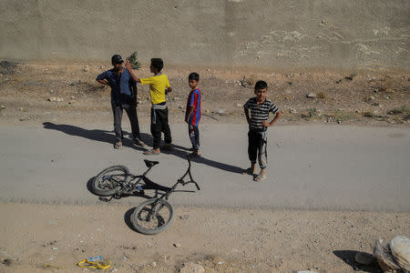 Children are seen from a train traveling through the outskirts of Damascus towards recently opened international fair in Damascus, Syria, September 15, 2018. REUTERS/Marko Djurica/Files