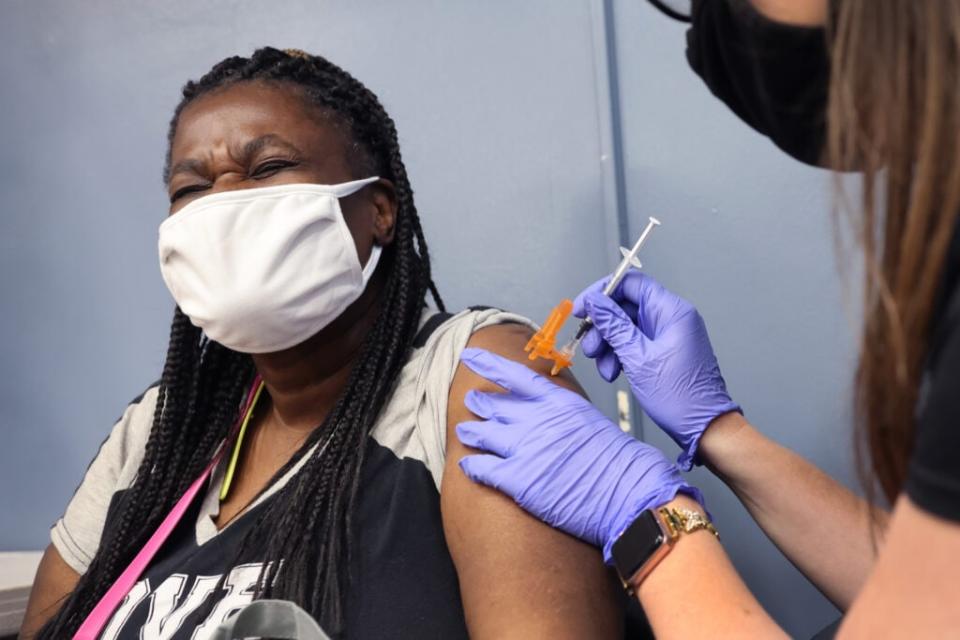 Marilyn Hallom gets a COVID-19 vaccine from Amanda Kohler-Gopen at the It’s Official Barbershop in the West Englewood neighborhood on June 05, 2021 in Chicago, Illinois. (Photo by Scott Olson/Getty Images)