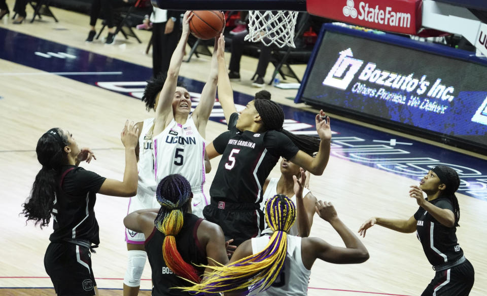 Connecticut guard Paige Bueckers (5) grabs a rebound against South Carolina forward Victaria Saxton (5) in the second half of an NCAA college basketball game in Storrs, Conn., Monday, Feb. 8, 2021. (David Butler/Pool Photo via AP)