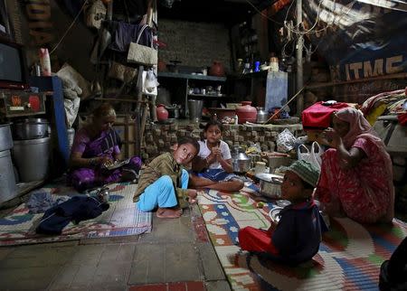 Family members of Mehboob Sheikh, 45, who died after consuming bootleg liquor, sit inside their house at a slum in Mumbai, June 20, 2015. REUTERS/Danish Siddiqui