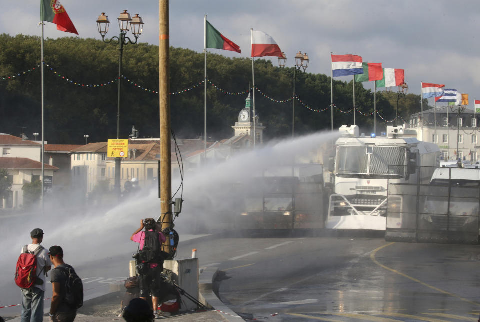 Police fire water cannon at protestors in Bayonne, France, Saturday, Aug. 24, 2019. World leaders and protesters are converging on the southern French resort town of Biarritz for the G-7 summit. Police have fired water cannon at about 400 anti-capitalist protesters blocking roads in a town near the venue of the G-7 summit. A few protesters threw rocks at police but the crowd in Bayonne was largely peaceful. (AP Photo/Bob Edme)