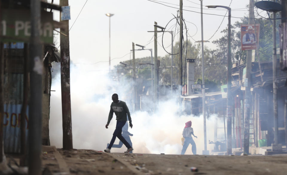 Protestors caught in tear gas in Kibera slums as they clash with police during a protest by supporters of Kenya's opposition leader Raila Odinga over the high cost of living and alleged stolen presidential vote, in Nairobi, Monday, March 20, 2023. (AP Photo/Brian Inganga)