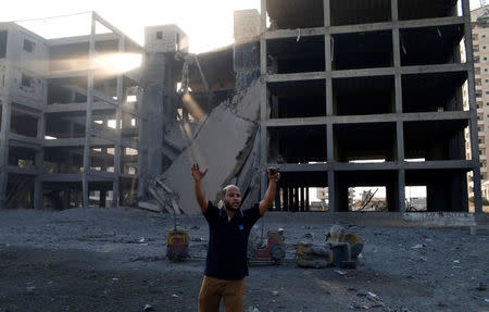 A Palestinian man reacts following an Israeli air strike on a building in Gaza City July 14, 2018. REUTERS/Mohammed Salem