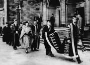 <p>Prince Philip, who was appointed Chancellor of the University of Wales, presents an honorary doctorate in music to his wife, Princess Elizabeth. </p>