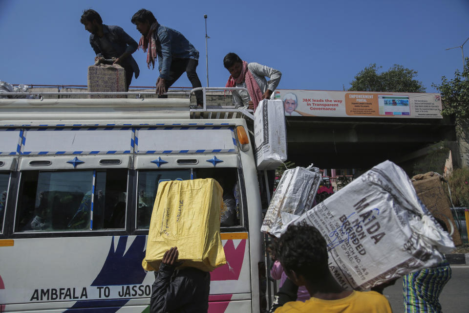 Indian migrant laborers load their luggages atop a bus as they prepare to leave for their homes from a bus station in Jammu, India on Oct. 19, 2021. A spate of recent killings has rattled Indian-controlled Kashmir, with violence targeting local minority members and Indian civilians from outside the disputed region. Assailants shot and killed five Indian migrant workers this month increasing the death toll in targeted killings to 32 this year. (AP Photo/Channi Anand)