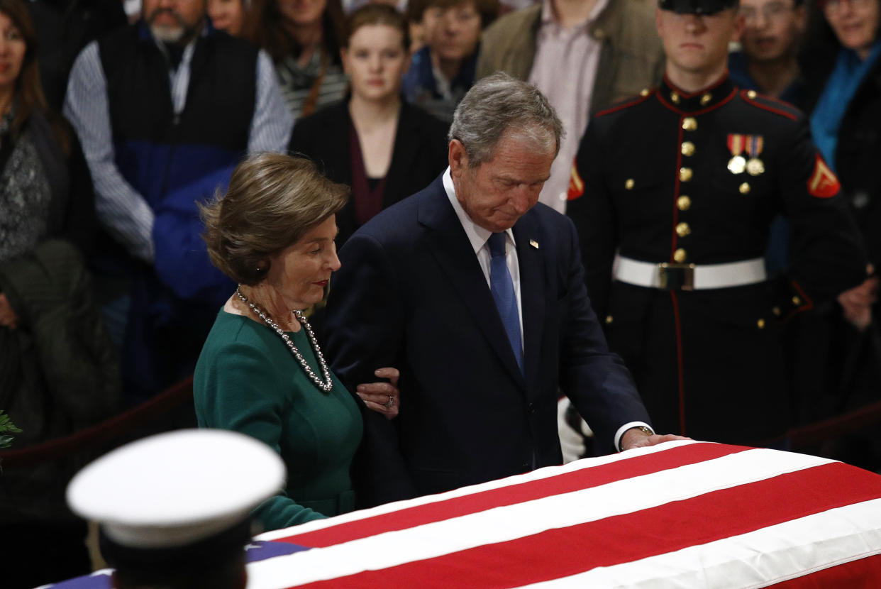 Former President George W. Bush and former first lady Laura Bush pause in front of the flag-draped casket of former President George H.W. Bush as he lies in state in the Capitol’s Rotunda in Washington, Tuesday, Dec. 4, 2018. (Photo: Patrick Semansky/AP)