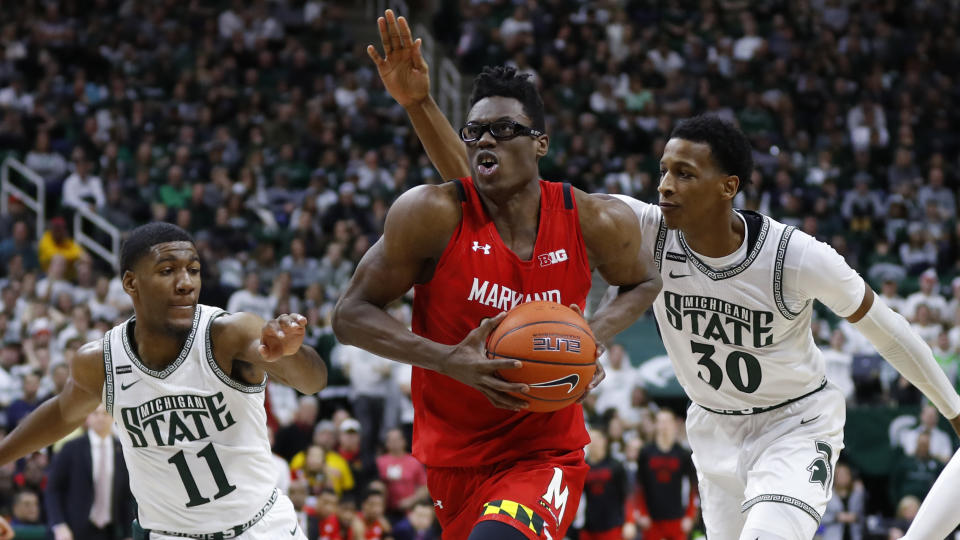 Maryland forward Jalen Smith (25) drives between Michigan State forward Aaron Henry (11) and Marcus Bingham Jr. (30) in the first half of an NCAA college basketball game in East Lansing, Mich., Saturday, Feb. 15, 2020. (AP Photo/Paul Sancya)