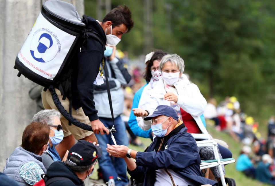 Hand sanitiser is distributed to fans ahead of the 9th Stage from Pau to Laruns.