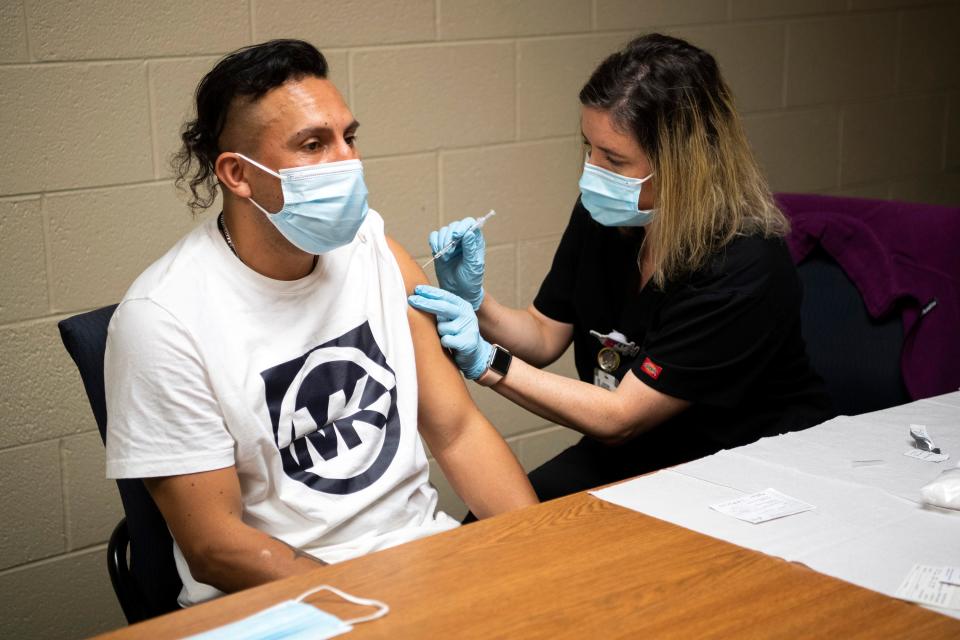 Knox County Health Department nurse Beverly Young, right, administers a COVID-19 vaccine during a clinic sponsored by Centro Hispano at Pellissippi State Community College's Division Street campus on March 23.